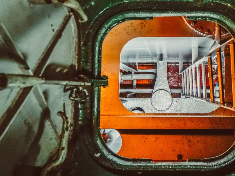 Looking down through an open manhole into an enclosed space