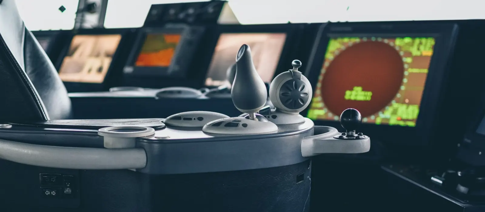 A ship's bridge console with radar and chart displays