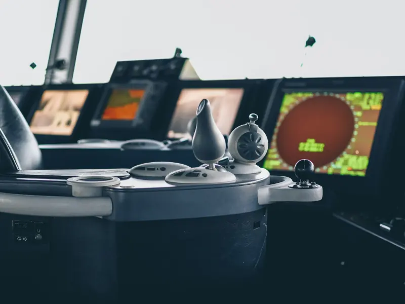 A ship's bridge console with radar and chart displays